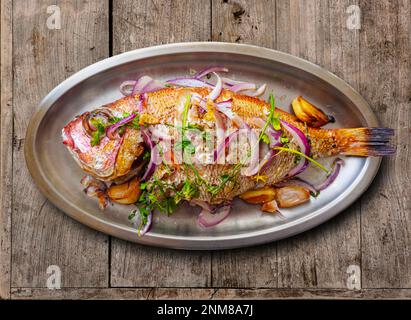 Baked Red Sea Bream plated on a metallic tray. Stock Photo