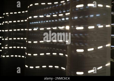 Curtains with sunlight stripes projected through the shutter slots Stock Photo