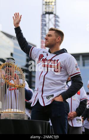 ATLANTA, GA - NOVEMBER 05: Atlanta Braves first baseman Freddie Freeman (5)  holds the World Series trophy over his head in celebration as the confetti  falls during the championship celebration for the