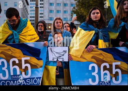 Madrid, Spain. 24th Feb, 2023. People carrying placards and wearing Ukrainian flags are seen during a protest where members of the Ukrainian community have gathered to protest against the Russian invasion of Ukraine, demanding peace and the end of war, coinciding with the first anniversary of Russia's invasion of Ukraine. Credit: Marcos del Mazo/Alamy Live News Stock Photo