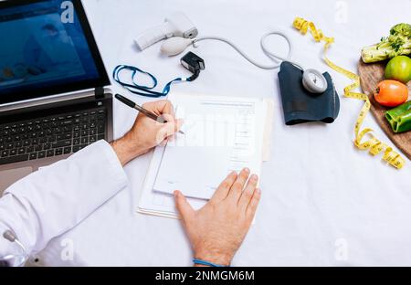 Top view of nutritionist writing on notepad. Concept of nutritionist taking notes on prescription, View of nutritionist taking medical records in the Stock Photo