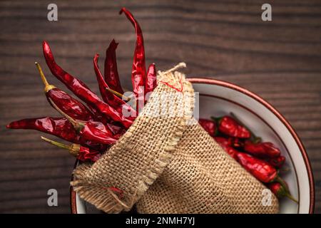 Group dried hot red chillies in a burlap sack Stock Photo