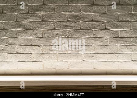 Beautiful space for product display, bricks wall with rough white painted, long shelf glass with light from below, volumetric light. Blank space for p Stock Photo