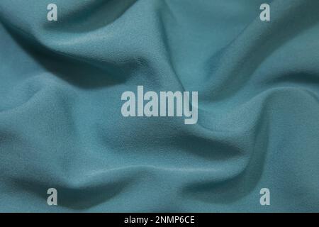 Turquoise fabric background. Turquoise cloth waves background texture. Turquoise fabric cloth textile material. Stock Photo