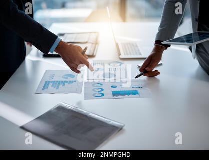 Two minds are better than one. two unrecognizable businessmen discussing paperwork at the table in the boardroom. Stock Photo