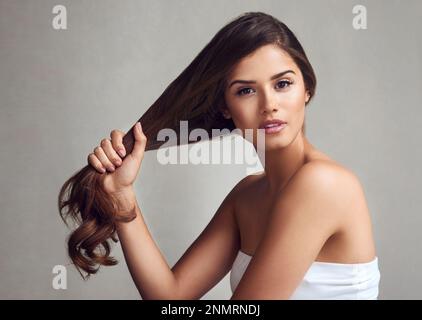 Premium Photo  Soft hair is a journey. studio shot of a beautiful young  woman showing off her long silky hair against a grey background.