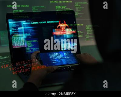 Cybersecurity, fraud and hands on a laptop and phone while programming or hacking a website. Scam, cyber attack and man hacker coding on a computer to Stock Photo