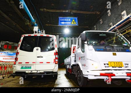 ORDOS, CHINA - FEBRUARY 24, 2023 - A new energy trackless rubber wheel vehicle (L) equipped with a driverless system avoids incoming vehicles at the S Stock Photo