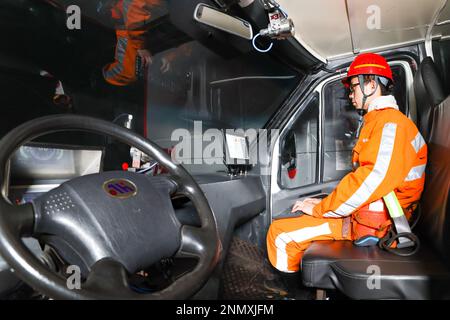 ORDOS, CHINA - FEBRUARY 24, 2023 - A safety officer rides on a new energy trackless rubber wheel vehicle equipped with a driverless system at the Shen Stock Photo