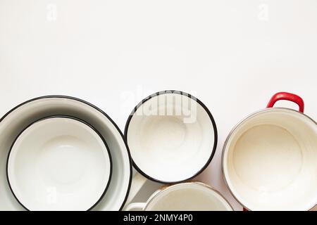 Various used enamel kitchen pots on a white background, a set of pots and a bowl of white Stock Photo