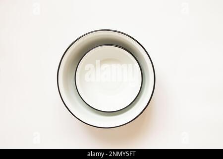 Various used enamel bowls on a white background, a set of pots Stock Photo
