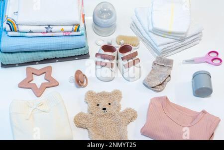 Concept of giving birth. Set of clothes and accessories for newborn on ...