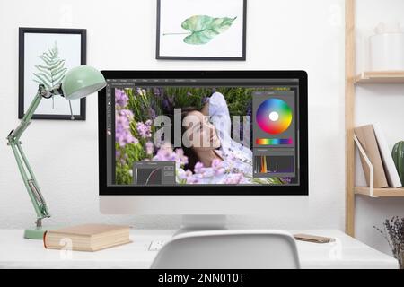 Designer's workplace. Computer with photo editor application on table indoors Stock Photo