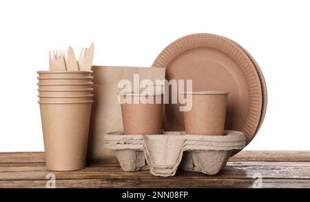 Set of disposable eco friendly dishware on wooden table against white background Stock Photo