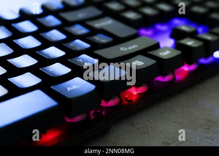 Modern keyboard with RGB lighting on grey table, closeup Stock Photo