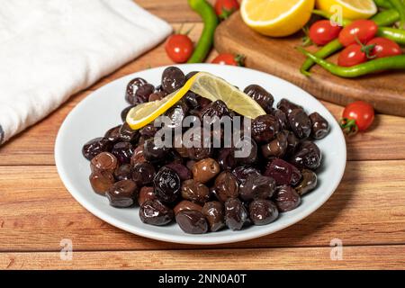 Black olive. Fermented olives and lemon slice in plate. Mediterranean flavors Stock Photo