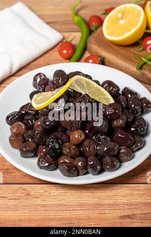 Black olive. Fermented olives and lemon slice in plate. Mediterranean flavors Stock Photo