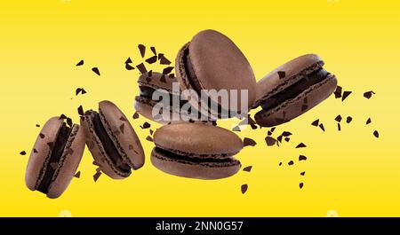 Sweet delicious macarons flying on yellow background Stock Photo