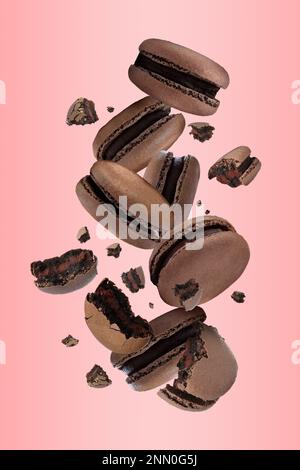 Sweet delicious macarons flying on pink background Stock Photo