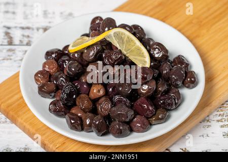 Black olive. Fermented olives and lemon slice in plate. Mediterranean flavors Stock Photo