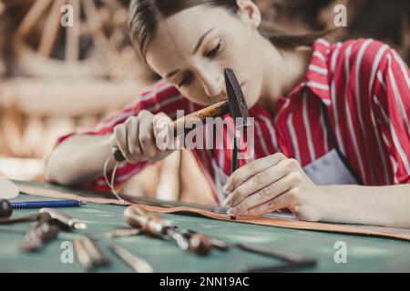 woman leather tailor artist handcraft working at own workshop small studio made by order masterwork piece Stock Photo