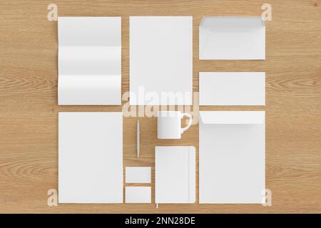 Blank corporate stationery set mockup with envelopes,  business cards, folder, trifold brochure, paper sheet, notebook, cup and pen on wooden backgrou Stock Photo