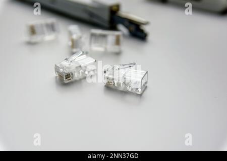 close-up of several rj45 connectors and other tools on a white table. Stock Photo