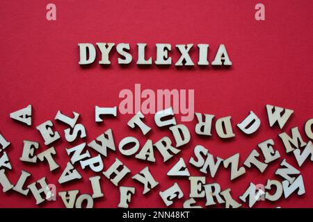 Dyslexia, word in wooden alphabet letters surrounded by random letters on red background Stock Photo