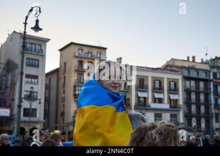 Pamplona, Spain. 24th Feb, 2023. A father holds his daughter with the Ukrainian flag. Ukrainian population gathered in the castle square of Pamplona on the occasion of the one-year anniversary of Russia's large-scale invasion of Ukraine. Credit: SOPA Images Limited/Alamy Live News Stock Photo