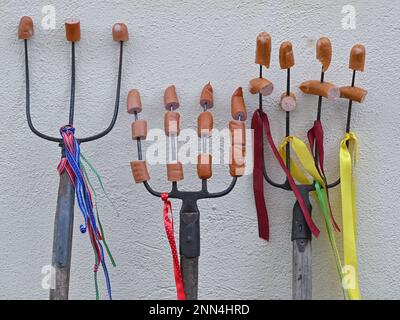 25 February 2023, Brandenburg, Lübbenau: Pitchforks with speared pieces of sausage stand on a wall during a break at the Zampern in the Spreewald. The pitchforks are props from the Rubisko association (Verein zur Pflege wendischer Trachten und Bräuche e.V.). With this so-called Zampern the winter is to be driven out. The members of the association were on the road as characters of old Spreewald stories. Like the sausage brother, the mold rider, the stork and bear, or the double person, spring and winter. The Rubisko association has made it its business to maintain and preserve the Sorbian and Stock Photo