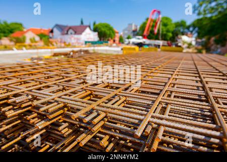 Pile of rusty rectangle steel reinforcement for concrete ready for installation placed at construction site. Stock Photo