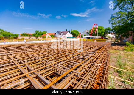 Pile of rusty rectangle steel reinforcement for concrete ready for installation placed at construction site. Stock Photo