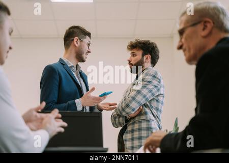 One of the two businessmen is disagreeing with the others offer in the office workspace Stock Photo