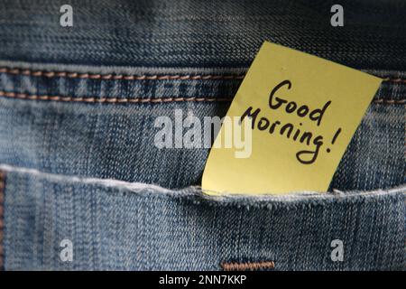 Good morning inscription on a tag in a pocket of blue jeans. Stock Photo