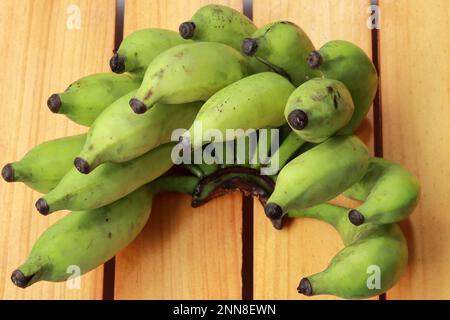 A collection of fresh yellow bananas arranged in an artistic display on a rustic wooden table Stock Photo
