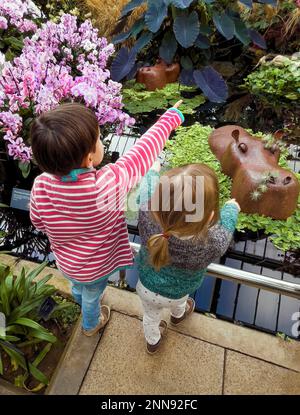 2023 Orchid Festival in Kew Gardens inspired by Cameroon, the African country.Two children in the Princess of Wales Conservatory enjoy their visit. Stock Photo