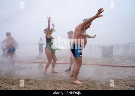 Ahlbeck, Germany. 25th Feb, 2023. Members of ice bathing clubs from Germany and Poland take a so-called ice shower on the beach in front of the pier. Storm and waves had prevented swimming in the Baltic Sea. The winter weather is currently cold and wet in northern Germany. Credit: Stefan Sauer/dpa/Alamy Live News Stock Photo