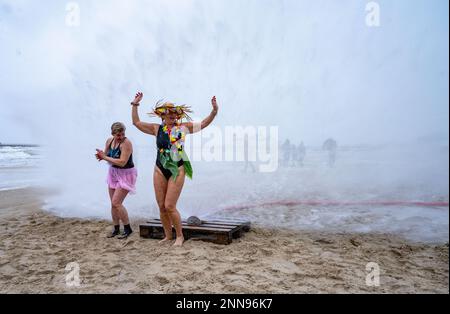 Ahlbeck, Germany. 25th Feb, 2023. Members of ice bathing clubs from Germany and Poland take a so-called ice shower on the beach in front of the pier. Storm and waves had prevented swimming in the Baltic Sea. The winter weather is currently cold and wet in northern Germany. Credit: Stefan Sauer/dpa/Alamy Live News Stock Photo