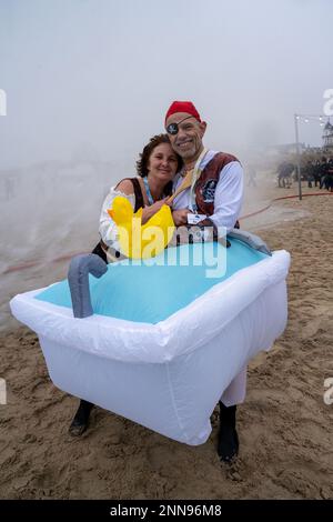 Ahlbeck, Germany. 25th Feb, 2023. Members of ice bathing clubs from Germany and Poland take a so-called ice shower on the beach in front of the pier. Storm and waves had prevented swimming in the Baltic Sea. The winter weather in northern Germany is currently cold and wet. Credit: Stefan Sauer/dpa/Alamy Live News Stock Photo