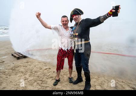 Ahlbeck, Germany. 25th Feb, 2023. Members of ice bathing clubs from Germany and Poland take a so-called ice shower on the beach in front of the pier. Storm and waves had prevented swimming in the Baltic Sea. The winter weather is currently cold and wet in northern Germany. Credit: Stefan Sauer/dpa/Alamy Live News Stock Photo