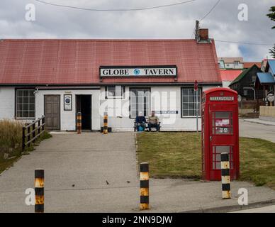 Port Stanley, Falkland Islands - 31 January 2023: Two tourists with beer outside the Globe Tavern Stock Photo