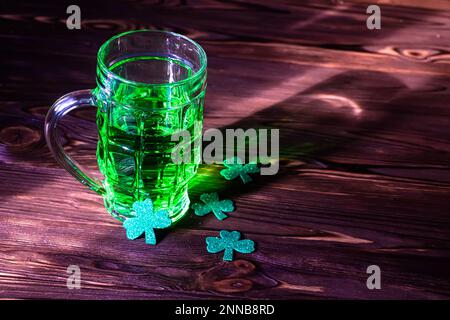 Celtic party. A lucky trilstnik with a glass of green beer in the bar for the holiday St. Patrick's Day. Stock Photo