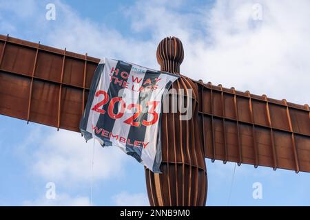 Gateshead, UK. February 25th, 2023. Landmark sculpture, Antony Gormley's  Angel of the North draped in a Newcastle United flag reading, 'Howay the Lads 2023 Wembley', as the men's football team head to Wembley Stadium to take on Manchester United in the Carabao Cup final tomorrow. The black and white striped flag is thought to have been erected by fans' group Wor Flags as they headed South for the match in the early hours of Saturday morning. Credit: Hazel Plater/Alamy Live News Stock Photo