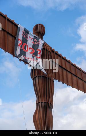 Gateshead, UK. February 25th, 2023. Landmark sculpture, Antony Gormley's  Angel of the North draped in a Newcastle United flag reading, 'Howay the Lads 2023 Wembley', as the men's football team head to Wembley Stadium to take on Manchester United in the Carabao Cup final tomorrow. The black and white striped flag is thought to have been erected by fans' group Wor Flags as they headed South for the match in the early hours of Saturday morning. Credit: Hazel Plater/Alamy Live News Stock Photo