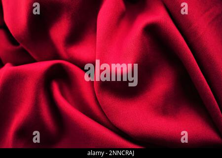 Vivid red crumpled elastic fabric background. Stock Photo
