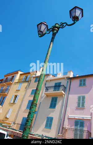 Beautiful, old street lamp in front of colorful houses in Saint-Tropez Stock Photo