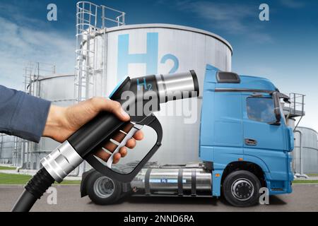 Hand with H2 fueling nozzle on a background of hydrogen fuel cell semi truck Stock Photo