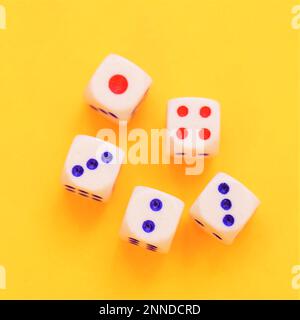 Five dice with different numbers on a orange sunny table. Stock Photo
