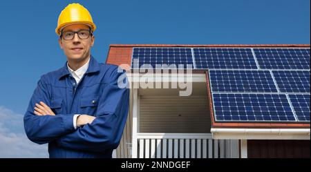Engineer on a background of house roof with solar panels Stock Photo