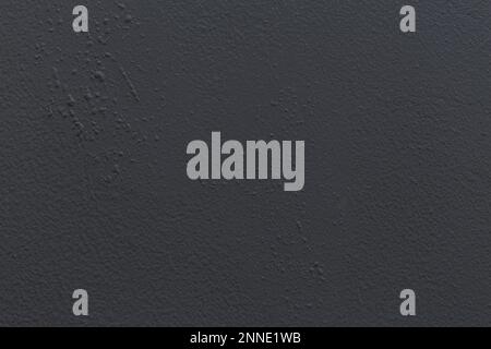 Dark textured wall surface with subtle rough details, ideal background for design and presentations. Stock Photo
